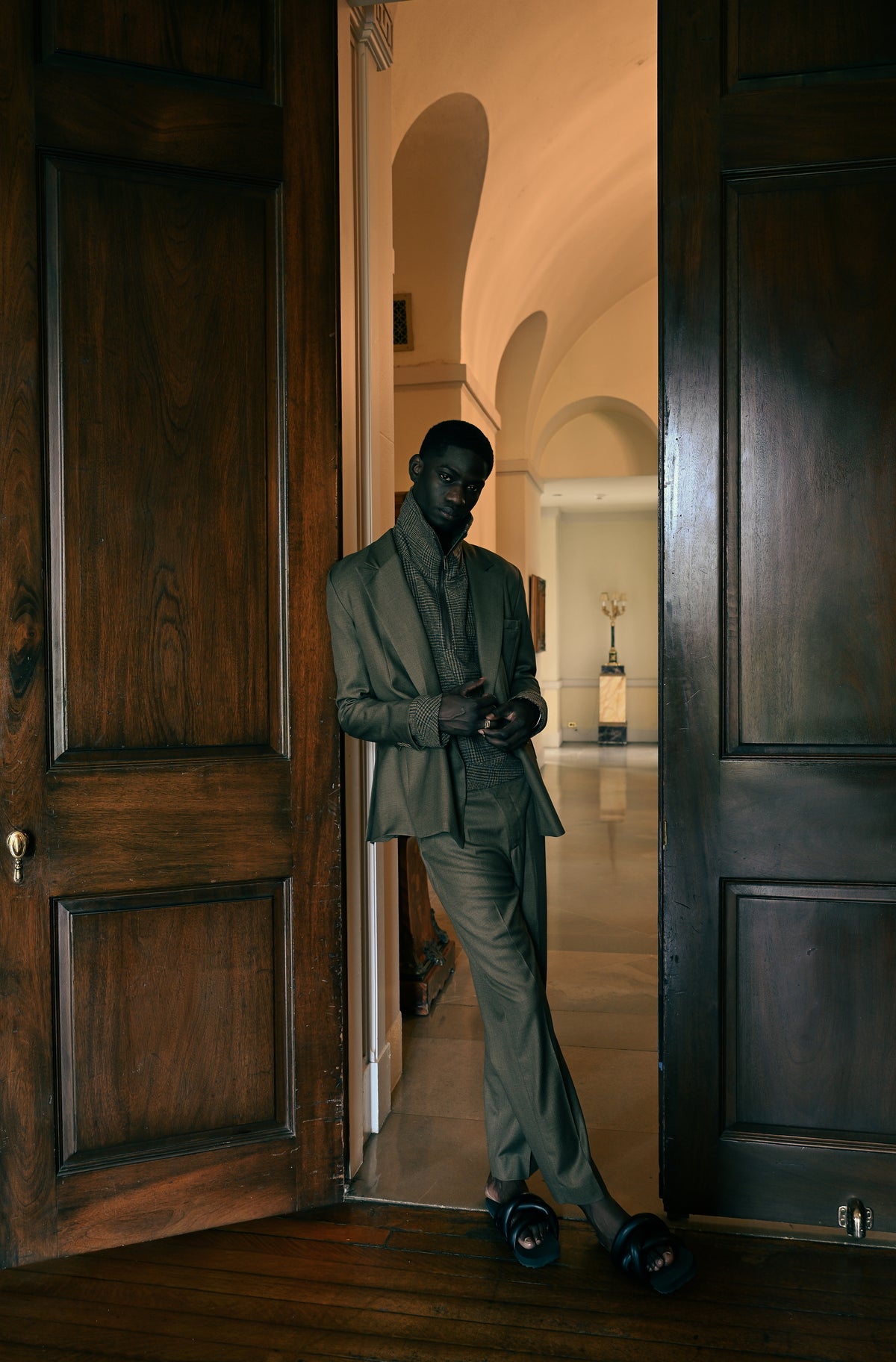 Pierre Blanc Autumn Winter 2026-27 campaign — tailored suit in a doorway